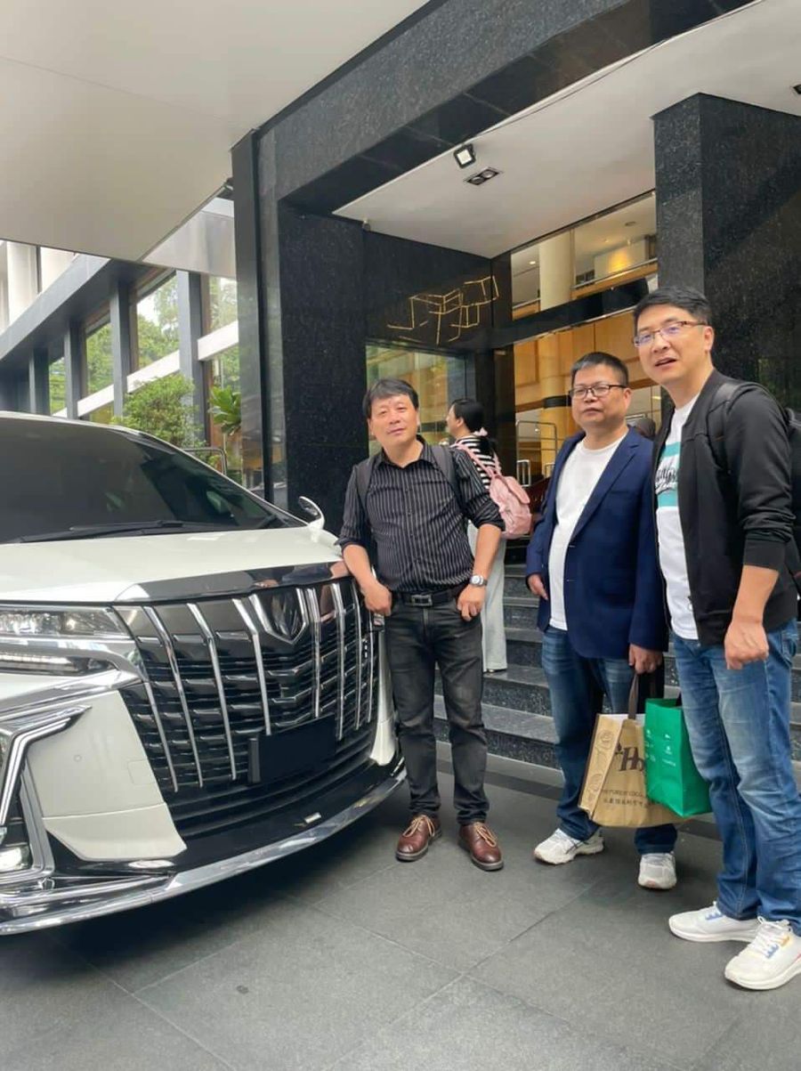 A group of customers beside a white Toyota Alphard